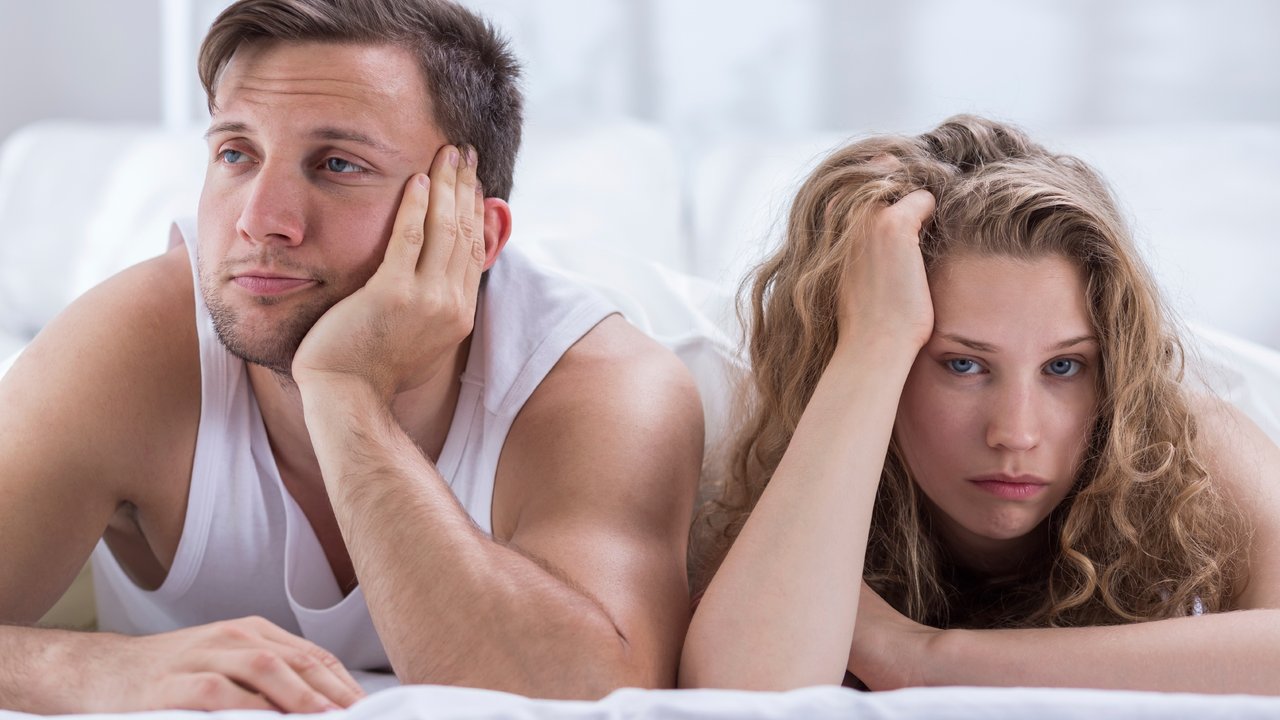 Young bored couple having problems in bedroom