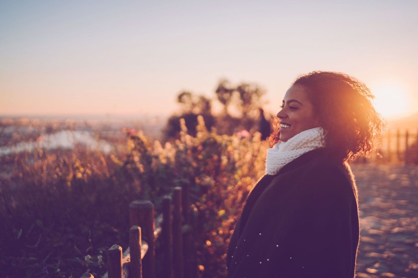 Frau, die herbstlichen Sonnenuntergang genießt Frau, die herbstlichen Sonnenuntergang genießt