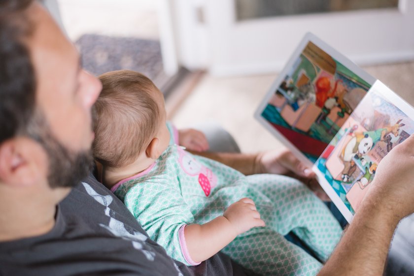 Papa liest Baby ein Buch vor