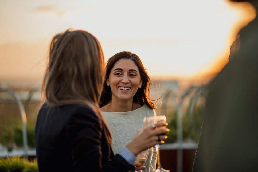 Freundinnen, die auf einem Dach Drinks genießen Freundinnen, die auf einem Dach Drinks genießen