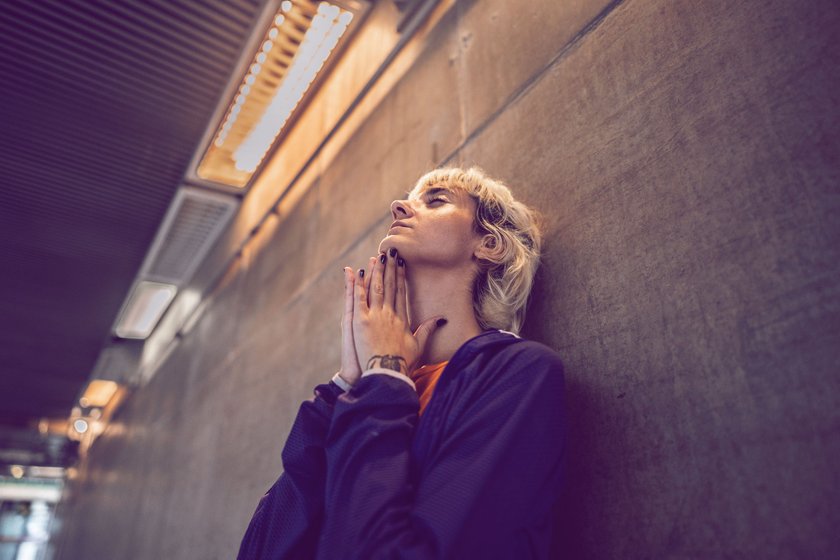 besorgte Frau, die sich an Wand lehnt besorgte Frau, die sich an Wand lehnt