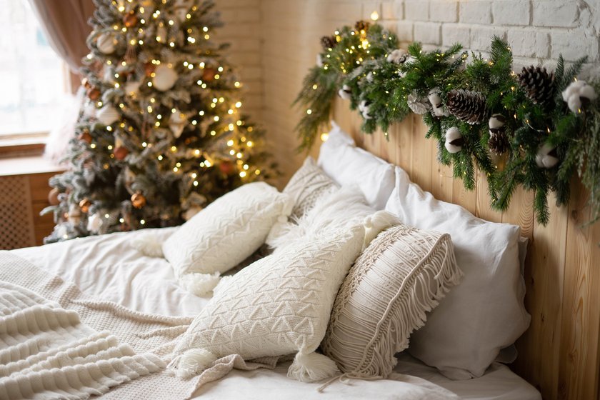 Decorated Christmas bedroom with Christmas tree. Light Scandinavian interior. Cozy bed in a chalet. Decorated Christmas bedroom with Christmas tree. Light Scandinavian interior. Cozy bed in a chalet.