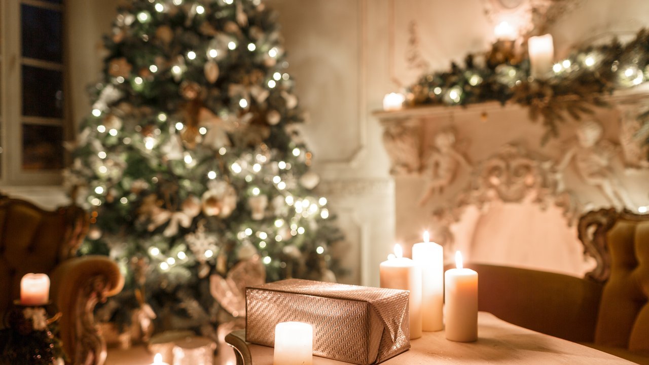 Eine weihnachtlich geschmücktes Wohnzimmer mit Kerzen auf dem Tisch, die leuchten Eine weihnachtlich geschmücktes Wohnzimmer mit Kerzen auf dem Tisch, die leuchten