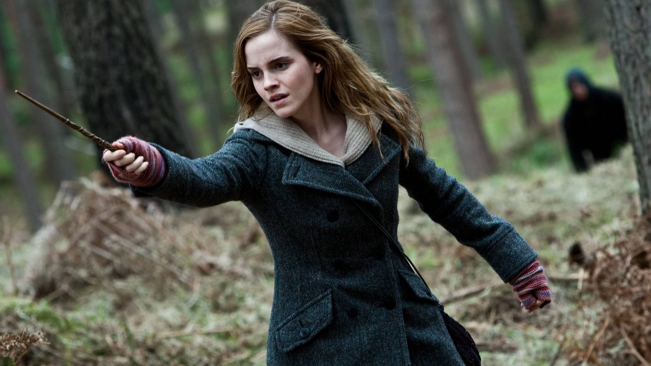 Die Figur Hermine Granger richtet mit der Hand ihren Zauberstab auf jemanden und trägt ein winterliches Outfit Die Figur Hermine Granger richtet mit der Hand ihren Zauberstab auf jemanden und trägt ein winterliches Outfit