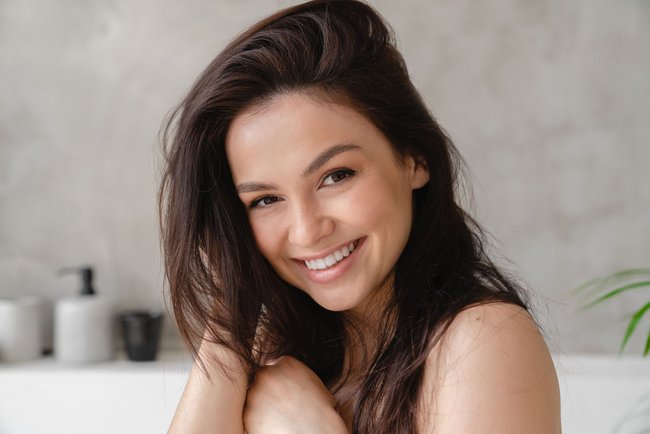 Young beautiful caucasian woman with shiny long brown straight hair touching it for good volume. Hair and skin care, beauty treatment concept Young beautiful caucasian woman with shiny long brown straight hair touching it for good volume. Hair and skin care, beauty treatment concept