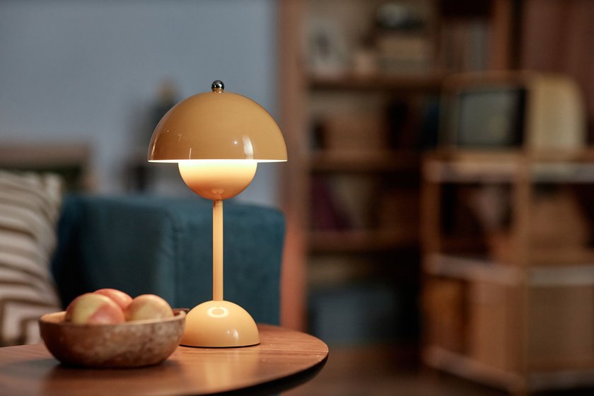 Eine gelbe Tischleuchte steht auf einem Tisch im Wohnzimmer und spendet gemütliches, warmes Licht Eine gelbe Tischleuchte steht auf einem Tisch im Wohnzimmer und spendet gemütliches, warmes Licht