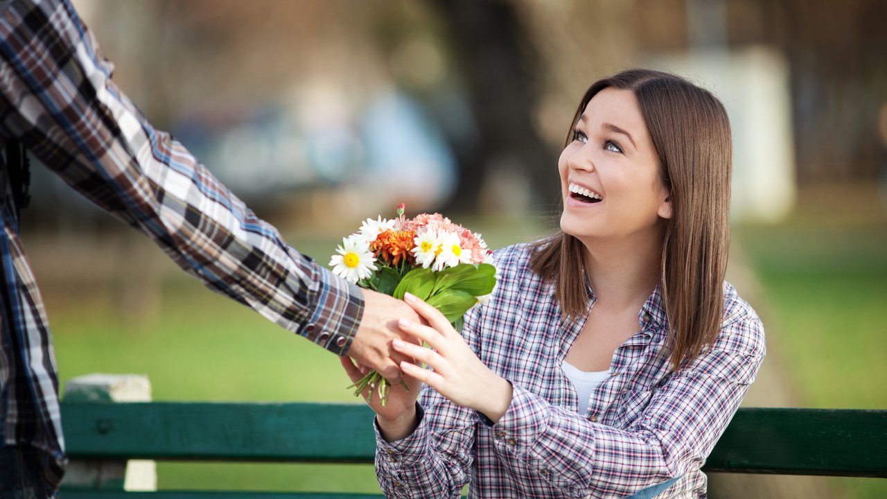 Mann überreicht Frau einen Blumenstrauß