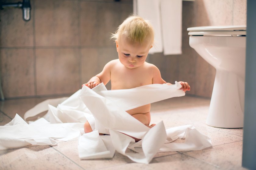 Kind spielt mit Toilettenpapier