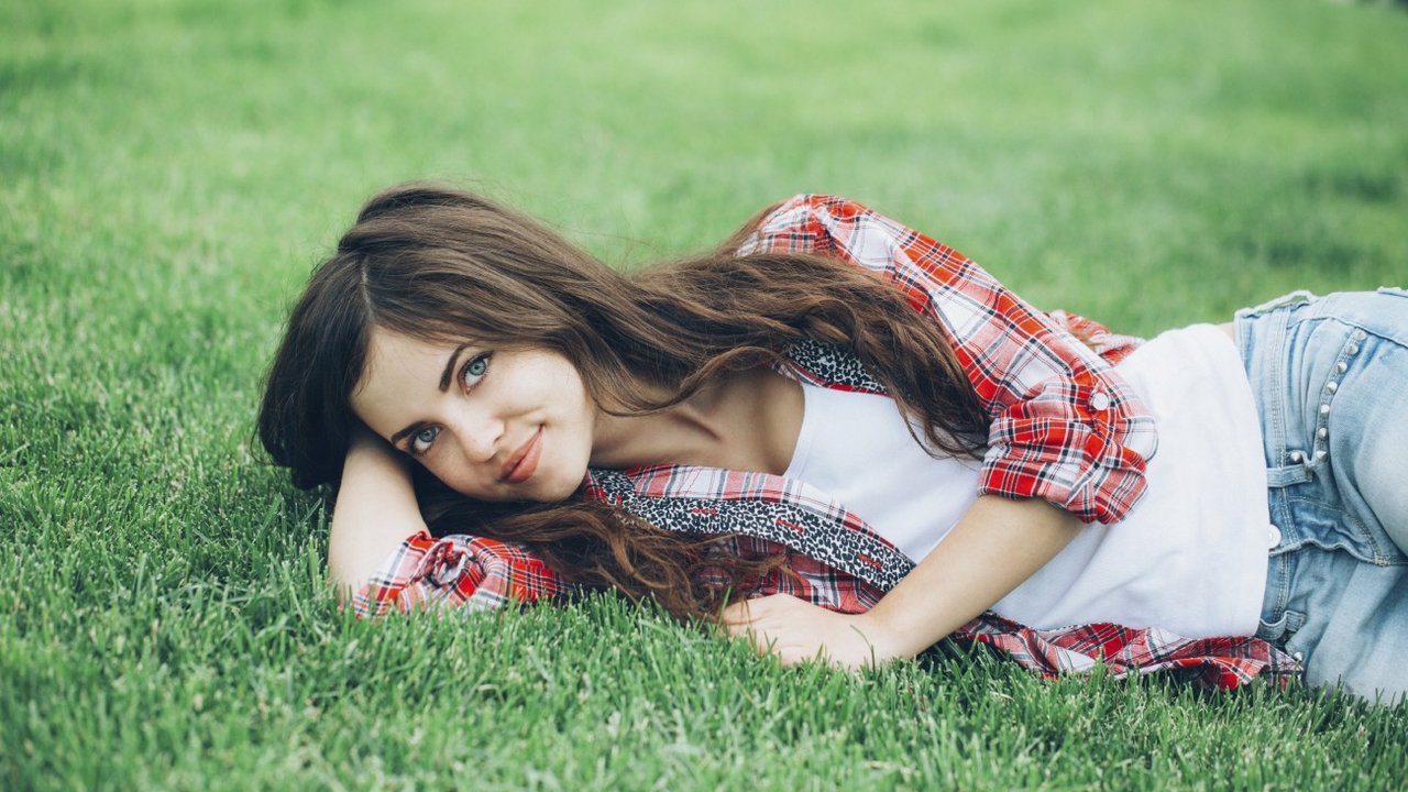 Beautiful girl student resting on the grass.