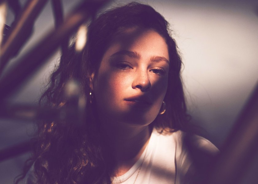 Frau, auf deren Gesicht eine Pflanze Schatten wirft Frau, auf deren Gesicht eine Pflanze Schatten wirft