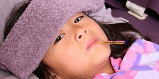 Kopfschmerzen bei Kindern: Mädchen im Bett mit Kopfweh.