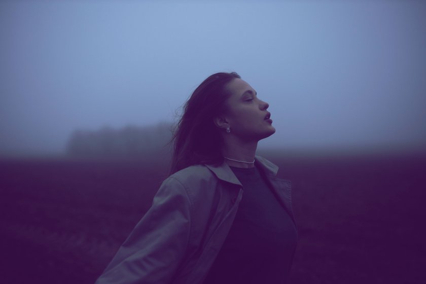 Frau steht auf einem Feld im Nebel Frau steht auf einem Feld im Nebel