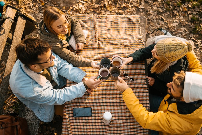 Freund*innen, die im Herbst ein Picknick draußen machen Freund*innen, die im Herbst ein Picknick draußen machen