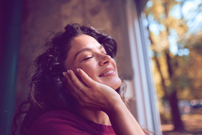 Frau, die vorm Fenster das Sonnenlicht genißet Frau, die vorm Fenster das Sonnenlicht genißet