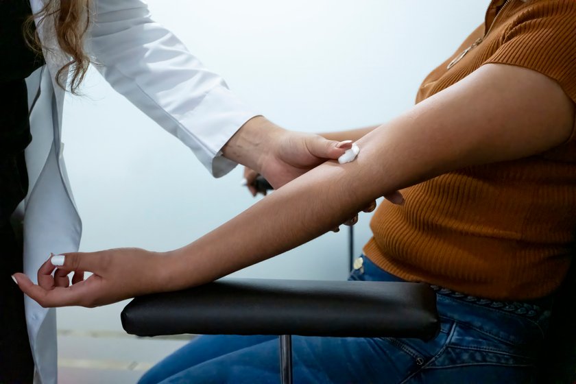 Nurse putting a cotton wool pad where draw blood Nurse putting a cotton wool pad where draw blood
