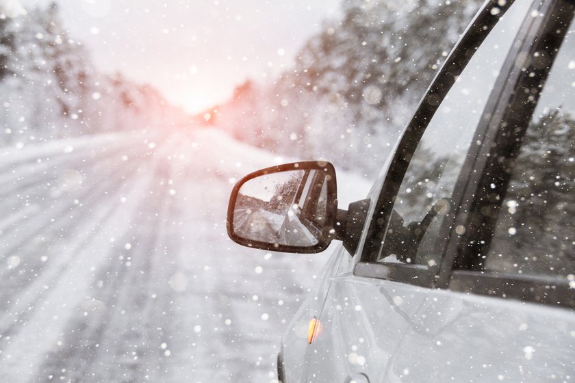 The winter road is reflected in the car's rear-view mirror The winter road is reflected in the car's rear-view mirror