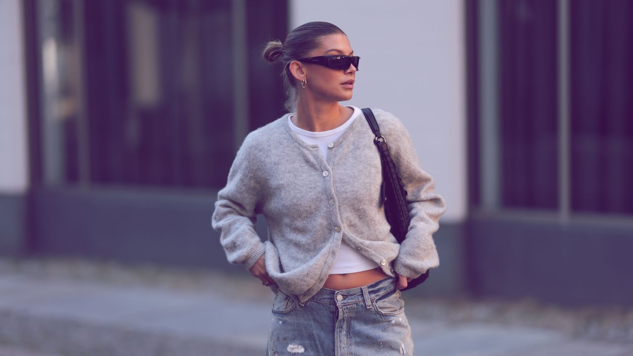 Frau mit Cardigan, Jeans und Sonnenbrille Frau mit Cardigan, Jeans und Sonnenbrille