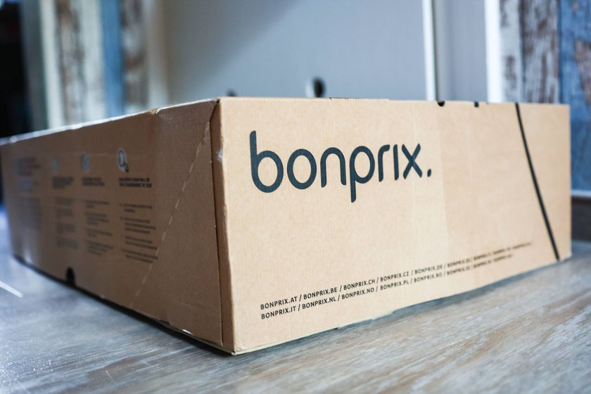 Ein Paket mit einem Bonprix Logo auf einer grauen Oberfläche Ein Paket mit einem Bonprix Logo auf einer grauen Oberfläche