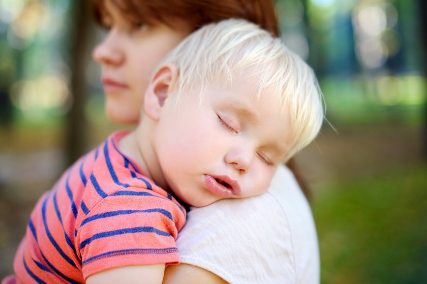 Kind ist auf dem Arm der Mutter eingeschlafen