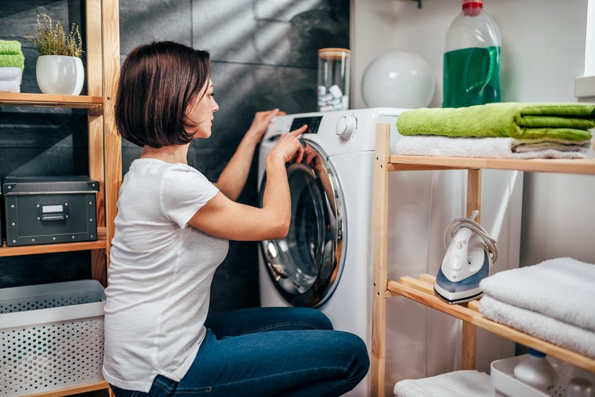 Frau stellt Waschmaschine an