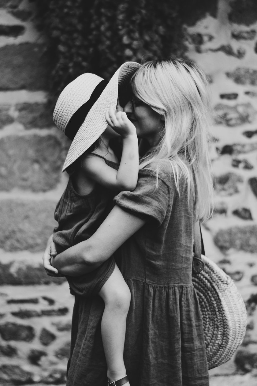 Mutter küsst Tochter in ihren Armen