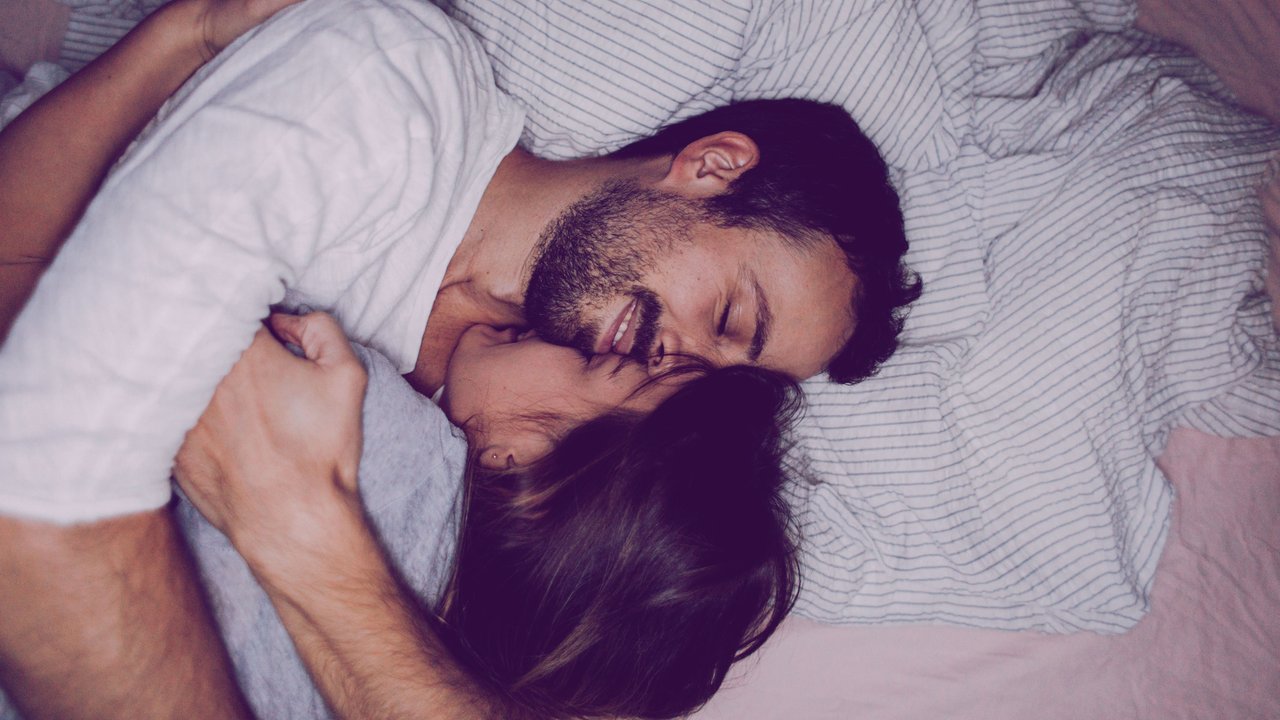 Paar kuschelt im Bett