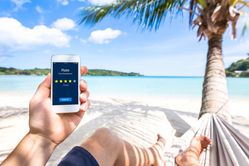Mann bewertet etwas auf dem Handy am Strand