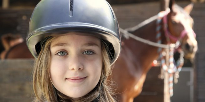 Reitunterricht: Mädchen mit Pferd.