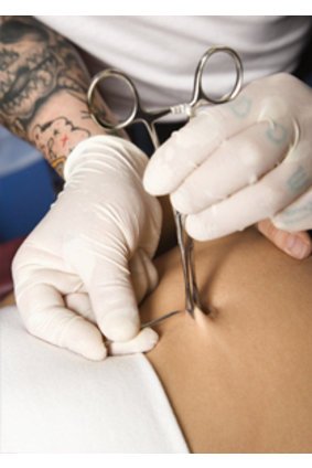 Bauchnabelpiercing wird vom Piercer gesetzt Bauchnabelpiercing wird vom Piercer gesetzt