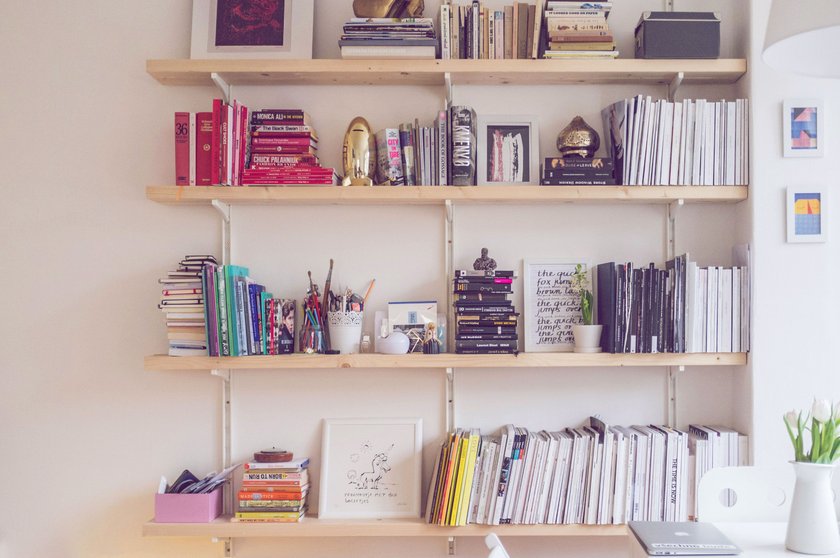 Bücherregal mit nach Farben sortierten Büchern
