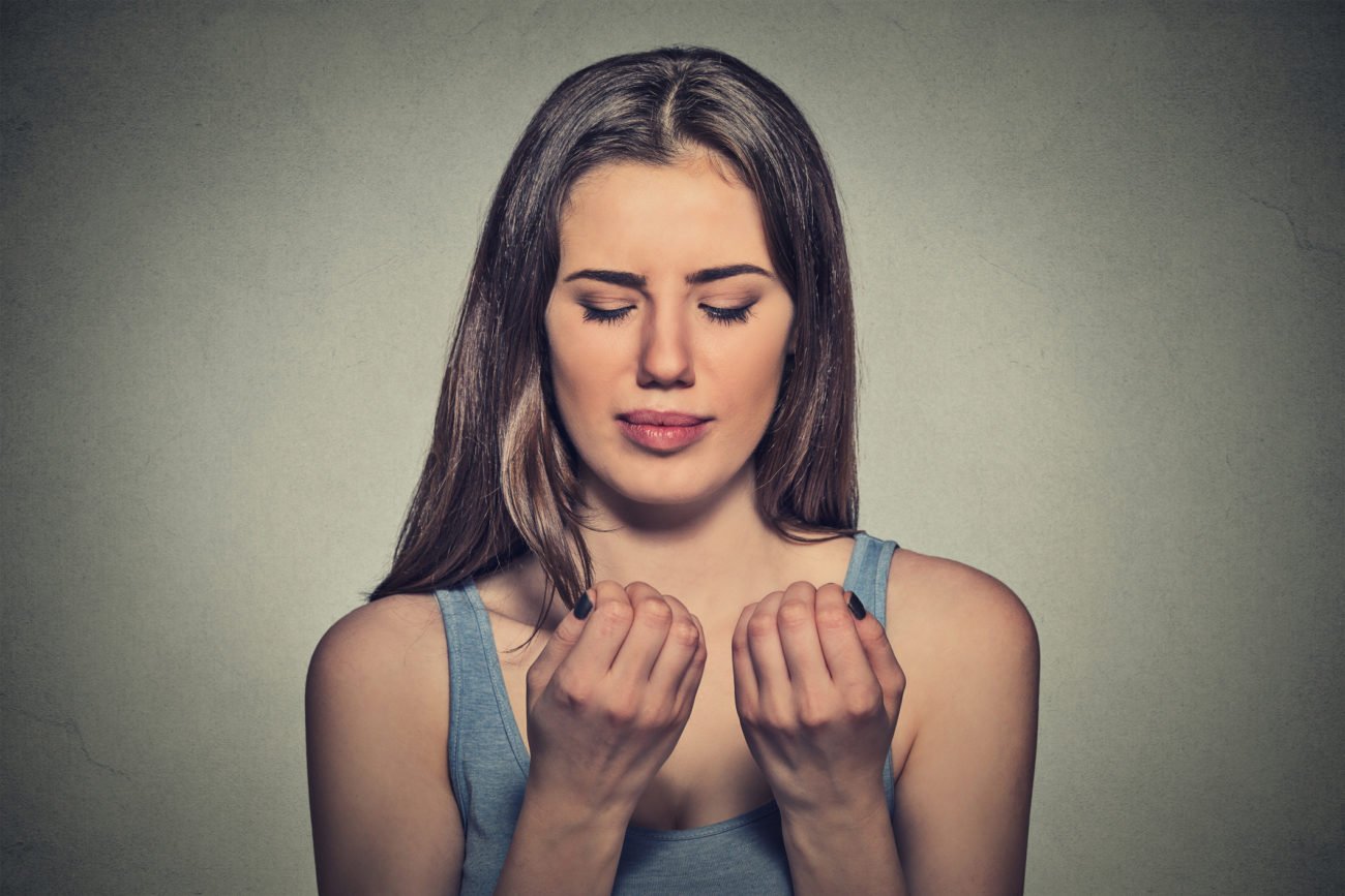 Frau schaut Fingernägel an Frau schaut Fingernägel an