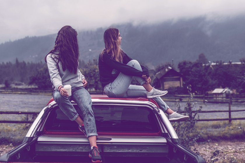 zwei Frauen, die auf einem Auto sitzen