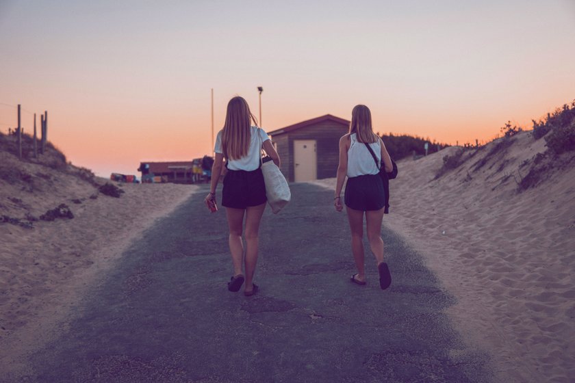 zwei Freundinnen, die zum Strand spazieren