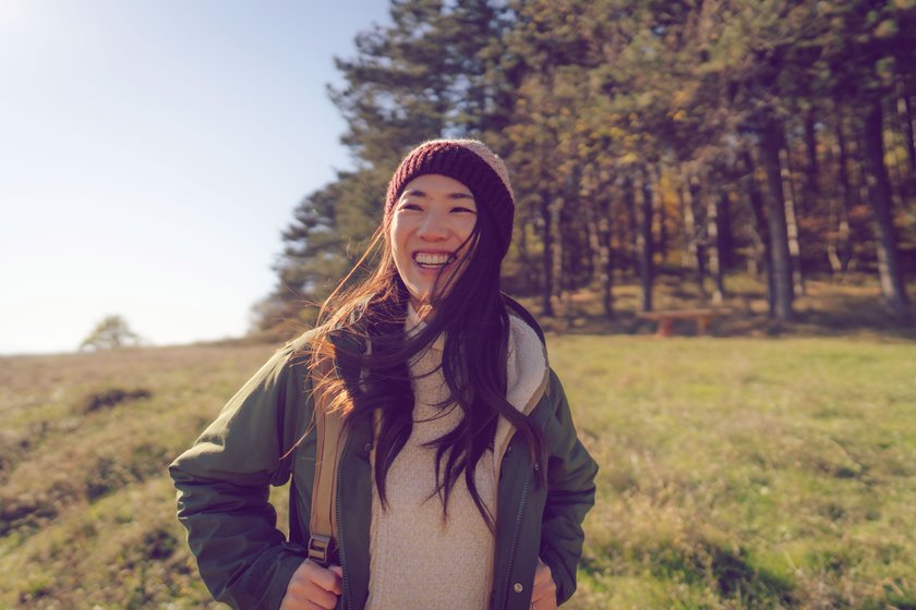 Lachende Frau beim Wandern im Wald