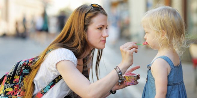 Babysitter füttert Kind mit Eis Babysitter füttert Kind mit Eis