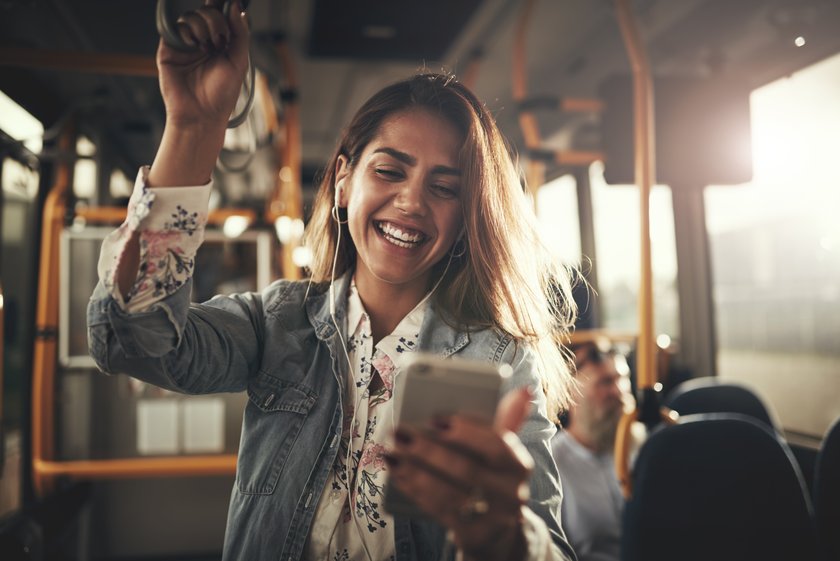 Frau hört Musik mit Kopfhörern im Bus