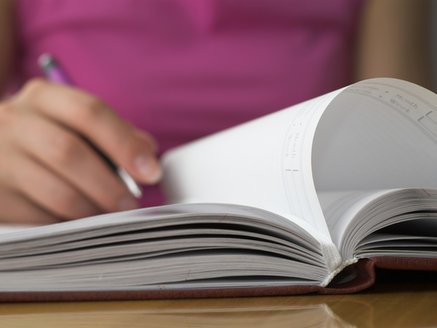 Frau nimmt Kalender, um ihre Schwangerschaftswoche zu berechnen Frau nimmt Kalender, um ihre Schwangerschaftswoche zu berechnen