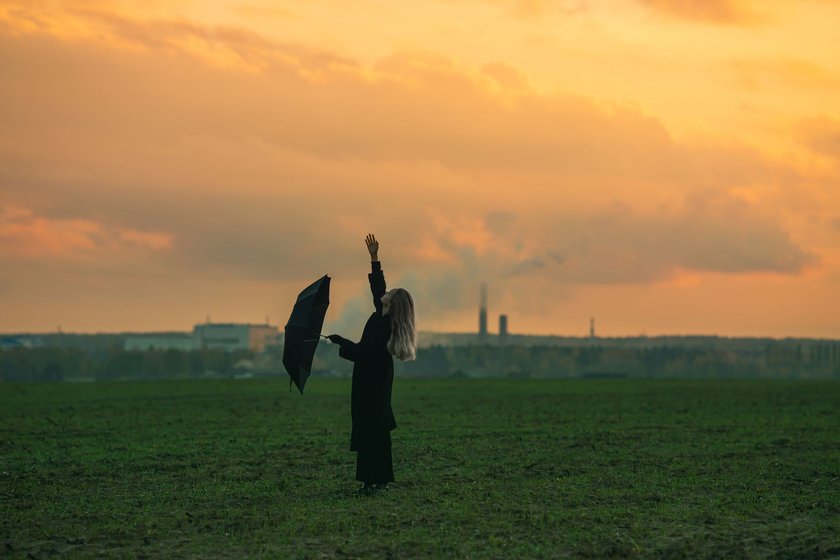 Frau mit einem Regenschirm auf dem Feld