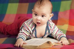 Baby, 3 Monate, mit einem Buch. Baby, 3 Monate, mit einem Buch.
