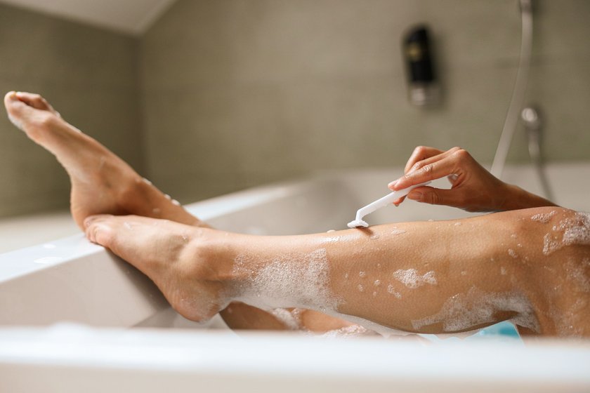Using a jaw razor, the woman meticulously shaves her hardwood legs, starting from the thigh down to the foot, while bathing in the chestdeep tub