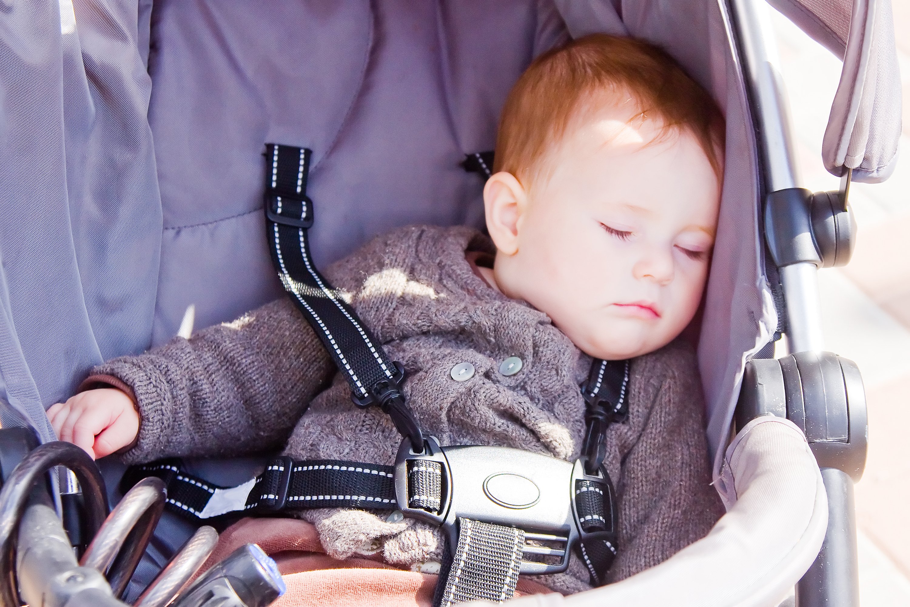 Kind schläft im Kinderwagen