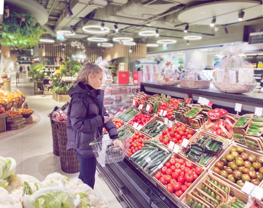 Frau im Supermarkt in der Gemüseabteilung im Winter