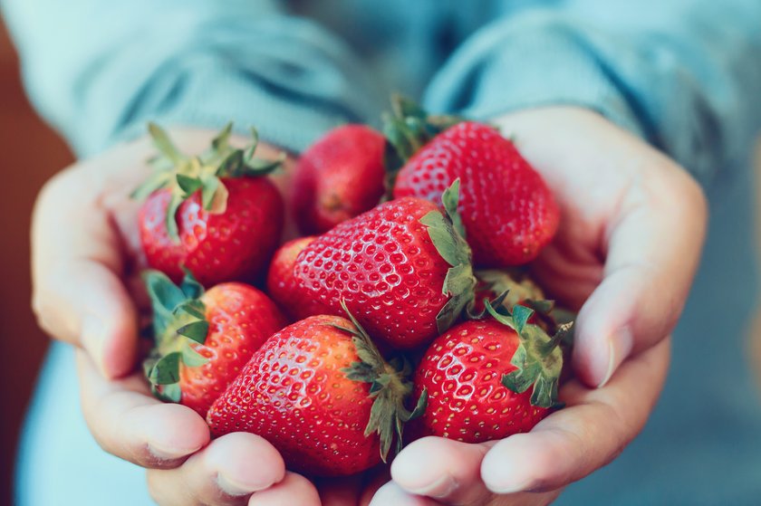 Frau hält Erdbeeren in ihren Händen