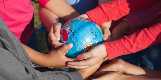 Bilingualer Kindergarten: Kinder halten eine Weltkugel in der Hand Bilingualer Kindergarten: Kinder halten eine Weltkugel in der Hand