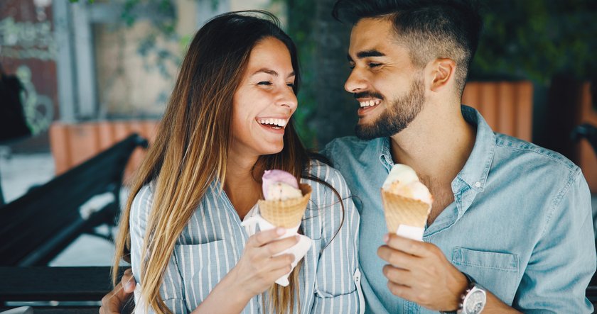 Verliebtes Paar isst zusammen Eis und lacht