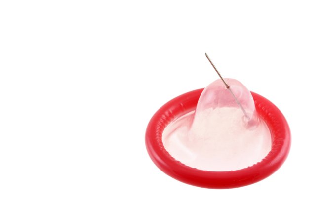 Kondom wird mit Nadel zerstochen