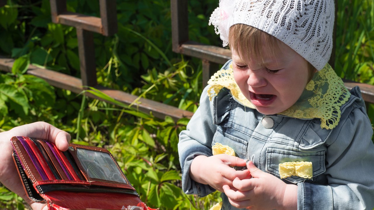 crying baby with empty purse outdoors
