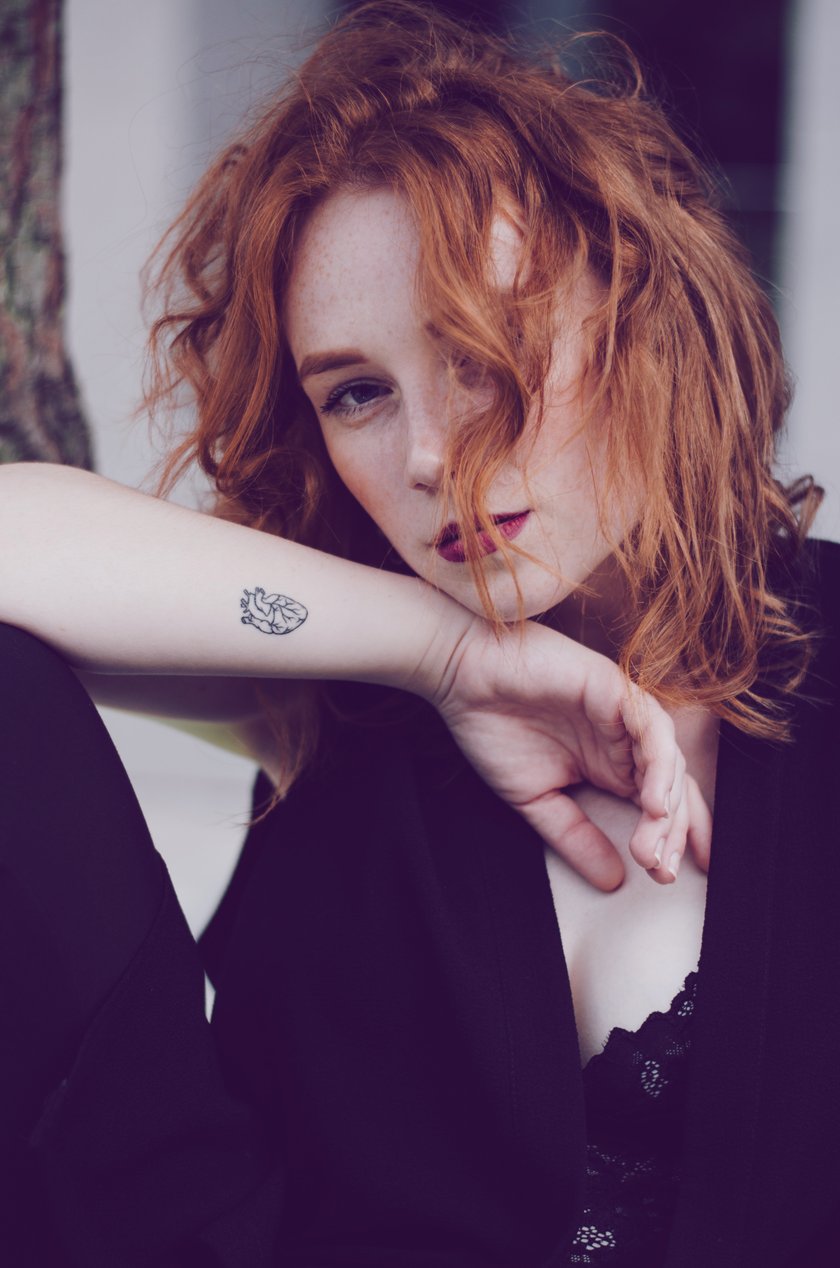 Frau mit Herz-Tattoo auf dem Arm