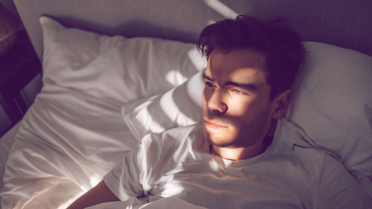 Mann liegt im Bett