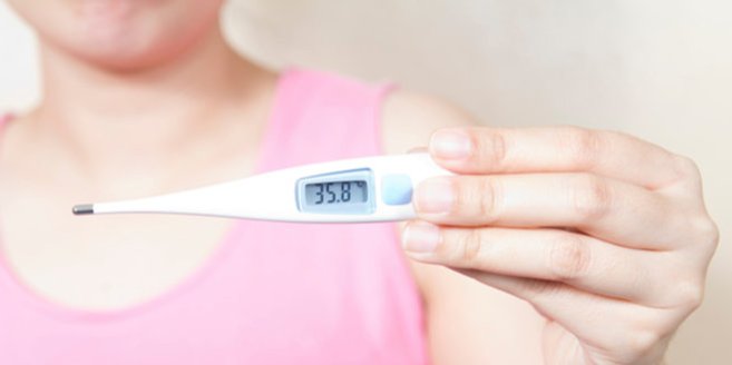 NFP: Frau hält Thermometer in die Kamera NFP: Frau hält Thermometer in die Kamera